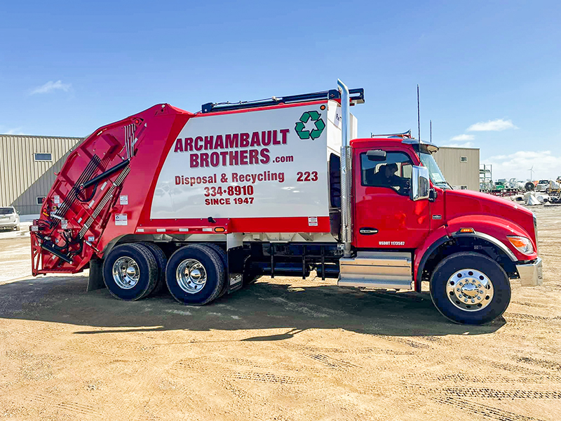 Clean red garbage truck with the Archambault Brothers logo and info on the side